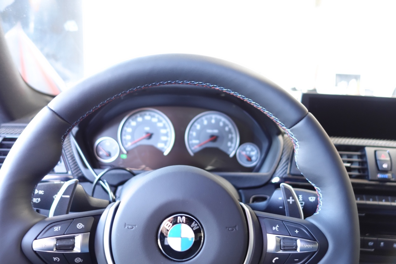 A big hearty steering wheel with paddle shifters and tri-color stitching. 