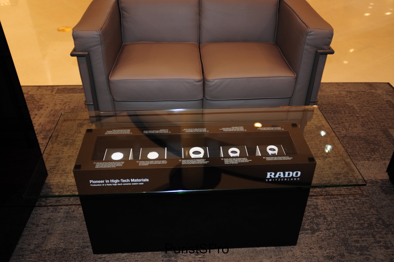 A lounge seating area with an innovative RADO coffee table display. The display shows the ceramic manufacturing process.