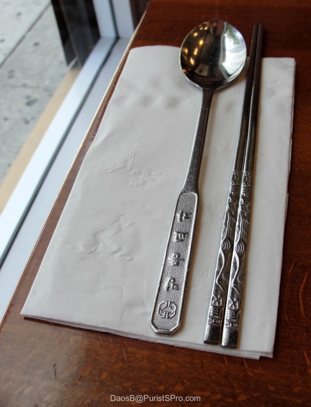 The long-handled soup spoon is stamped with the name of the restaurant in Korean characters.